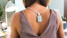 Person wearing the Upright GO S on the necklace while working at a desk